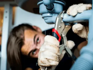 idraulico all'opera ripara la tubazione di un lavandino