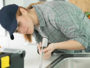 una donna cerca di riparare un lavandino